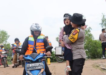 Polres Lampung Timur Siagakan Personel Bantu Penyebrangan Warga dan Anak Sekolah di Sungai Way Bungur